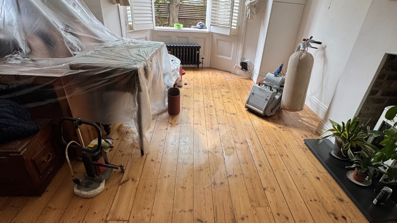 Wood Floor Sanding underway on Victorian pine floorboards inside a Stamford Hill bay-window lounge.