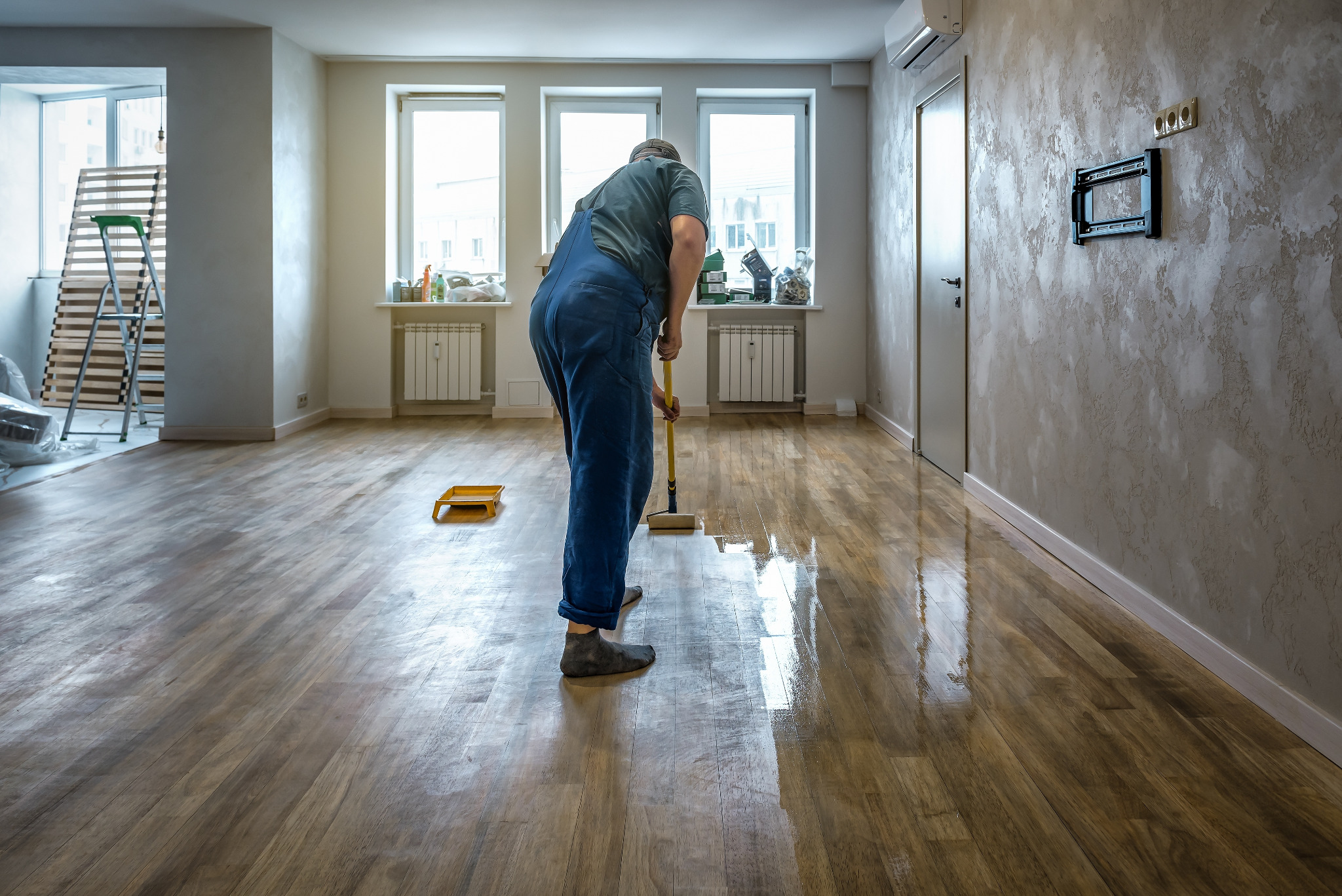 Hardwood Floor Refinishing in Stamford Hill – Solid Oak Plank, Final Coat Hardwood Floor Refinishing in Stamford Hill on a solid oak hardwood plank floor—technician rolling on the final clear coat for a glossy, even finish.