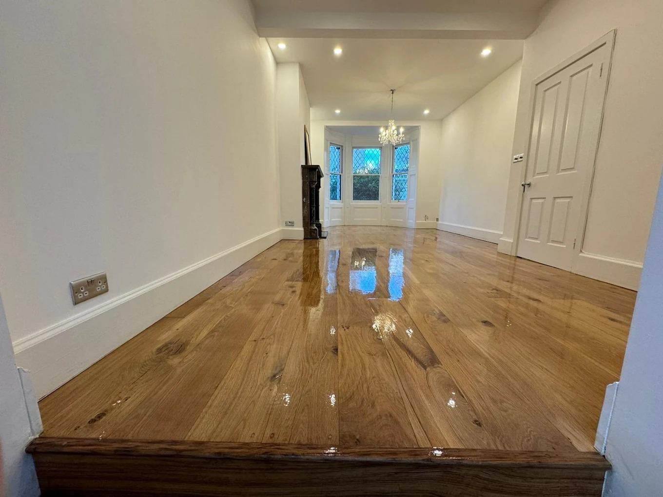 Hardwood Floor Refinishing in Stamford Hill on a solid oak hardwood reception room floor—freshly sanded and coated with a high-gloss protective lacquer.