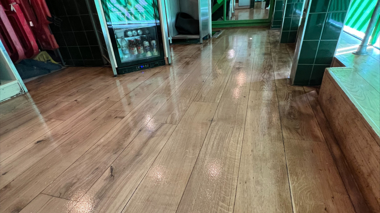 Commercial Floor Sanding in Stamford Hill, showcasing a freshly restored oak hardwood bar floor with a smooth, glossy finish and rich grain detail.