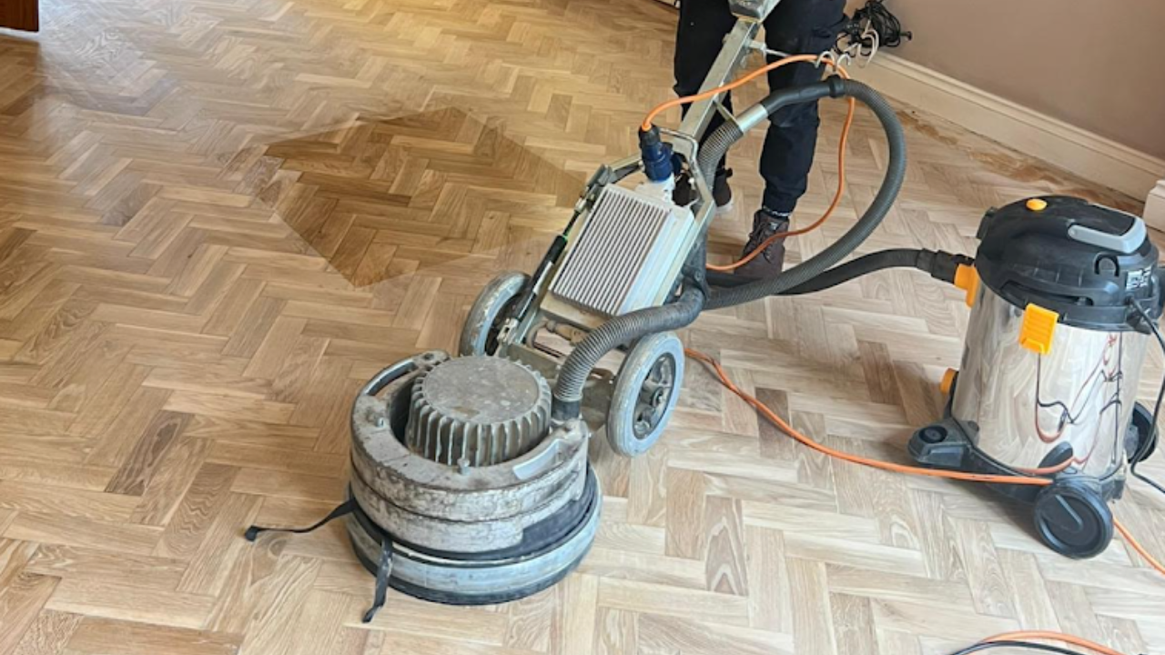 Parquet Floor Sanding in Stamford Hill on an oak herringbone parquet floor, with a dust-extraction buffer smoothing the surface for a clean, even finish.